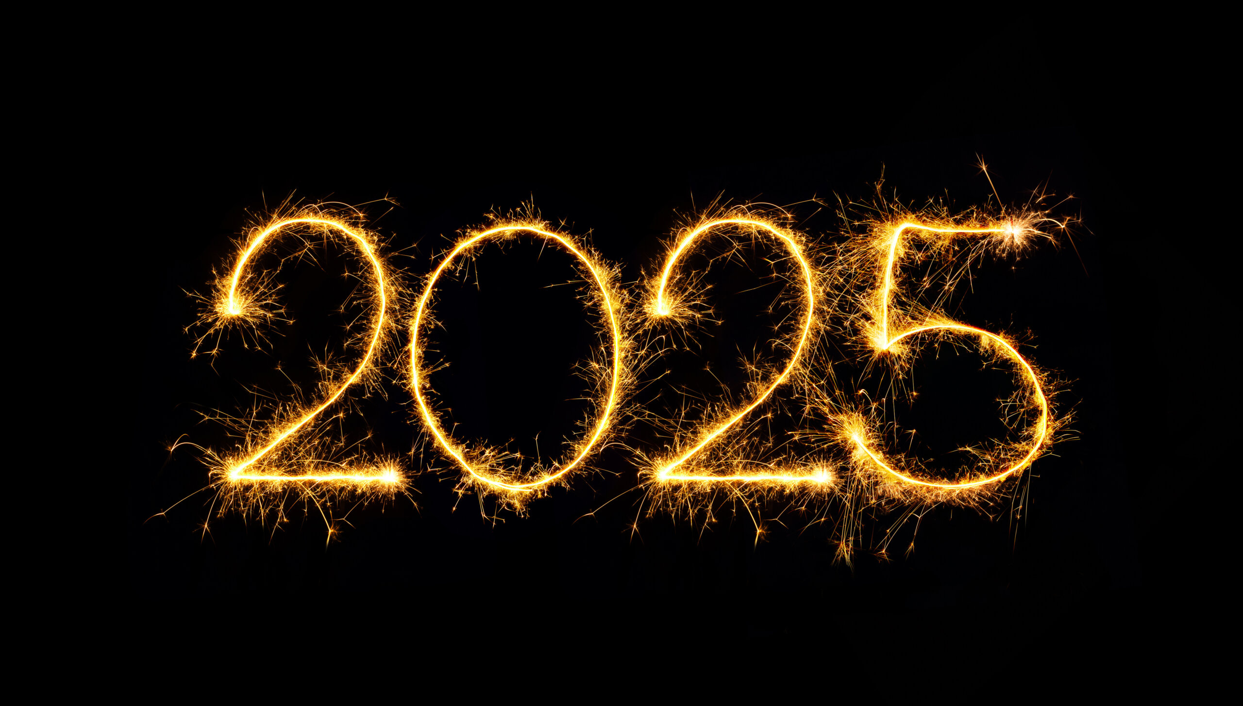 New Year 2025. Sparkling burning numbers Year 2025 isolated on black background. Beautiful Glowing golden overlay element for design holiday greeting card, billboard, flyer and Web banner