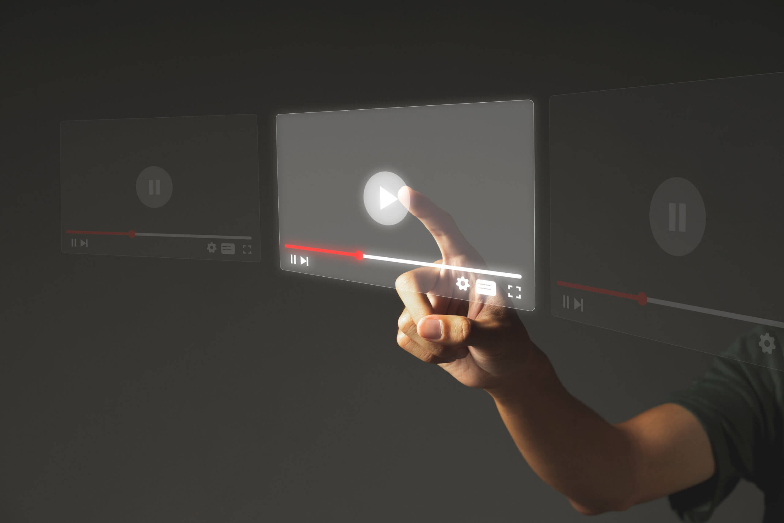 Hand pressing a futuristic digital play button on a transparent video interface.