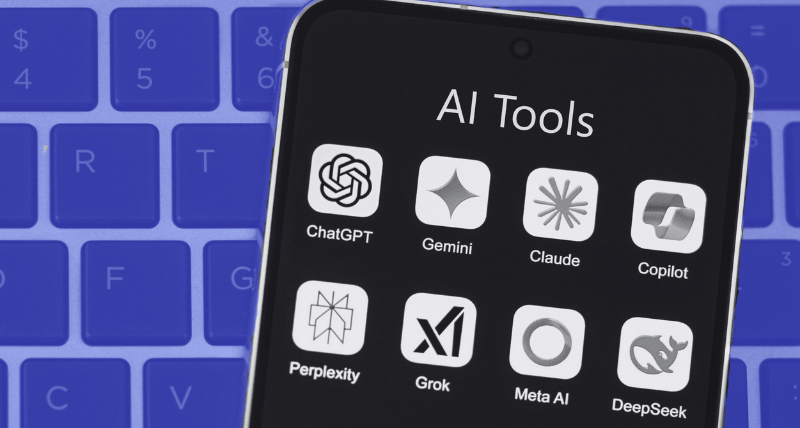 A smartphone screen showing a folder labeled “AI Tools” with app icons for ChatGPT, Gemini, Claude, Copilot, Perplexity, Grok, Meta AI, and DeepSeek, set against a blurred blue keyboard background.