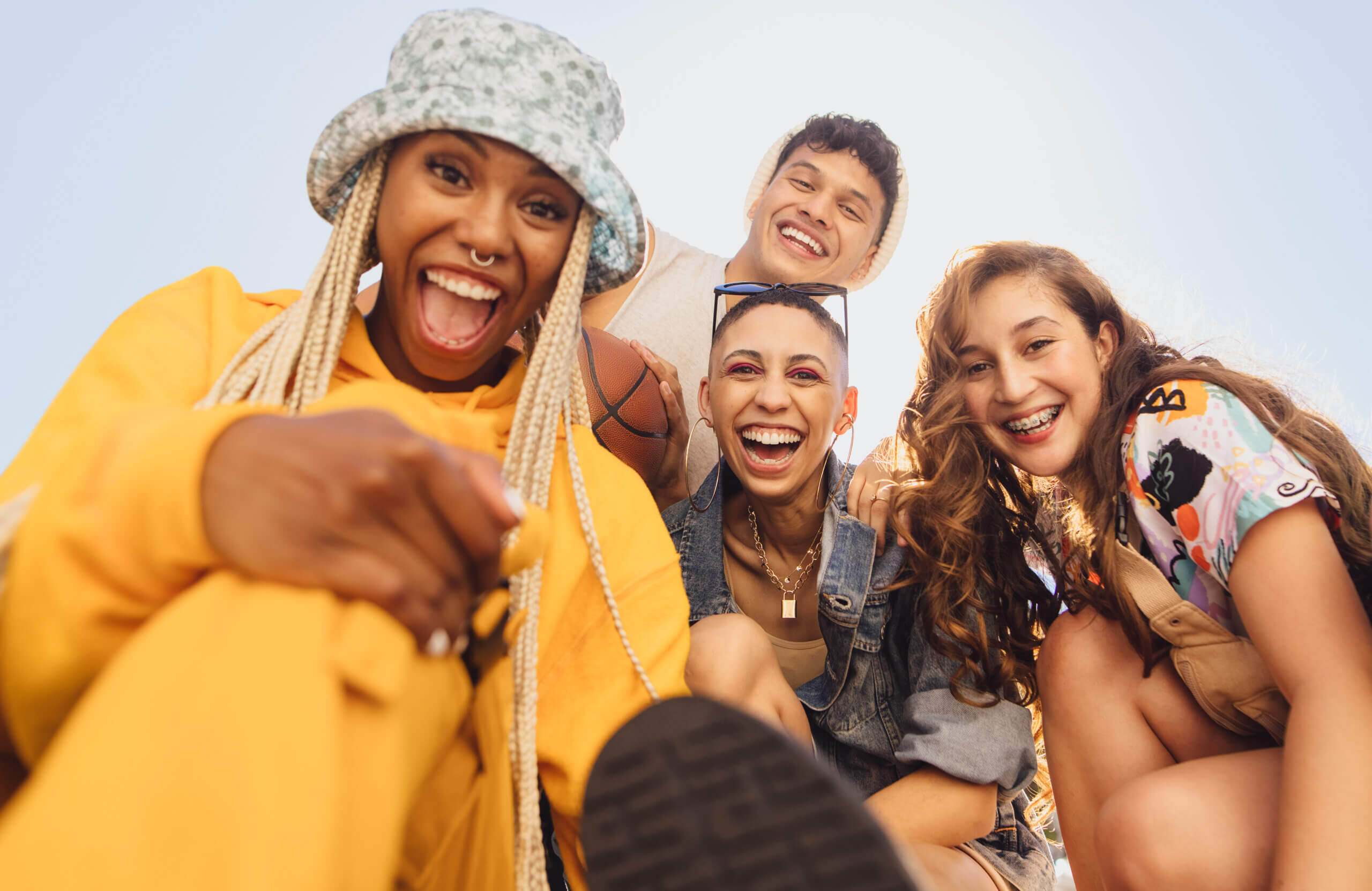 Cheerful generation z friends having fun together outdoors. Group of multiethnic friends smiling at the camera cheerfully. Vibrant young people making happy memories together.