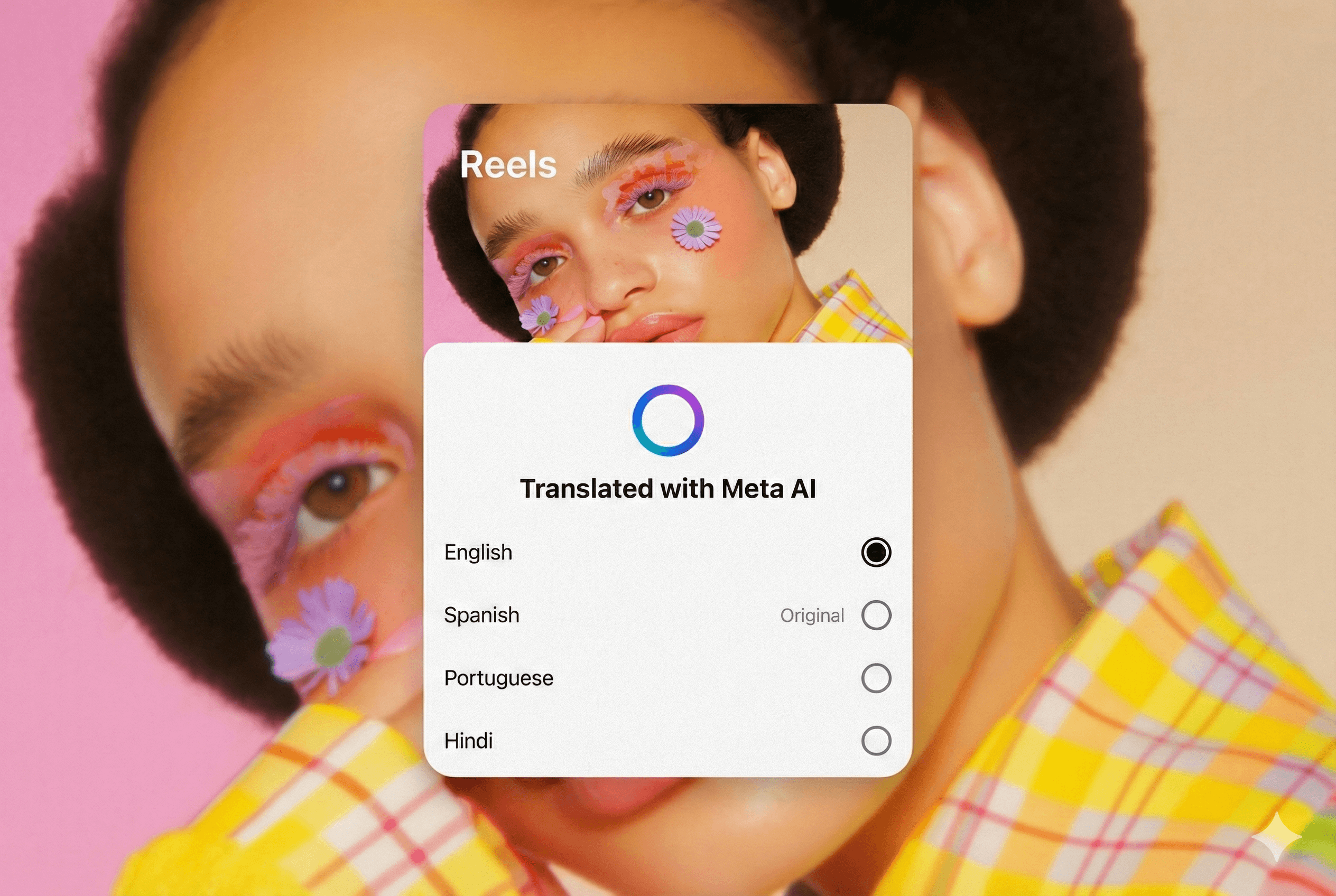 A user interface card labeled "Reels" floats over a blurred background image. The background features a close-up of a person with dark curly hair, wearing a yellow plaid shirt and creative orange and purple makeup with small purple flowers attached to their face. The interface card displays a clear, unblurred crop of the same person at the top. Below the image is a multicolored loading circle and the text "Translated with Meta AI." A list of language options follows: English (which is selected), Spanish (marked as "Original"), Portuguese, and Hindi.