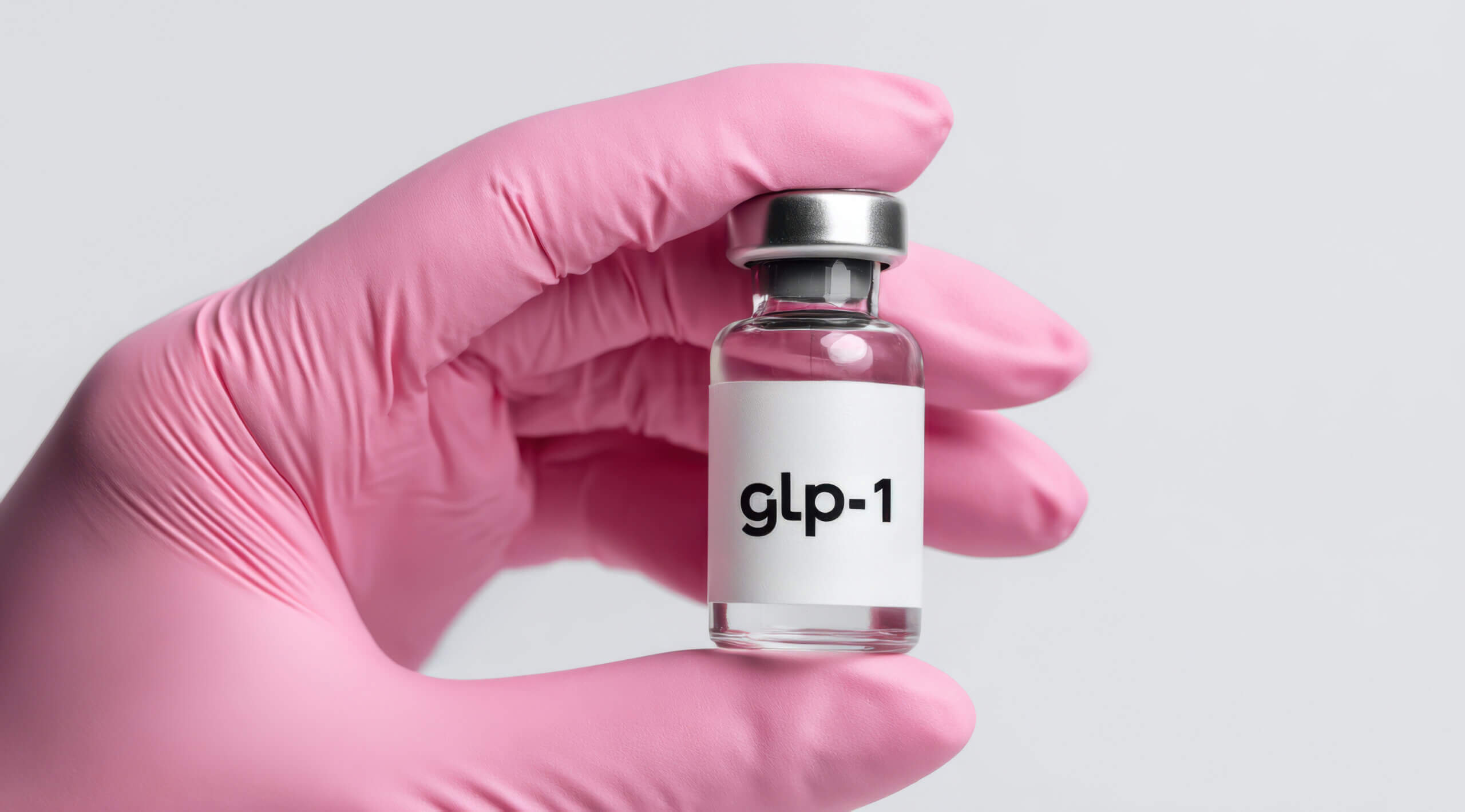 Healthcare professional wearing a pink protective glove holding a glp-1 medicine vial, symbolizing treatment for diabetes, weight loss management, and chronic disease prevention