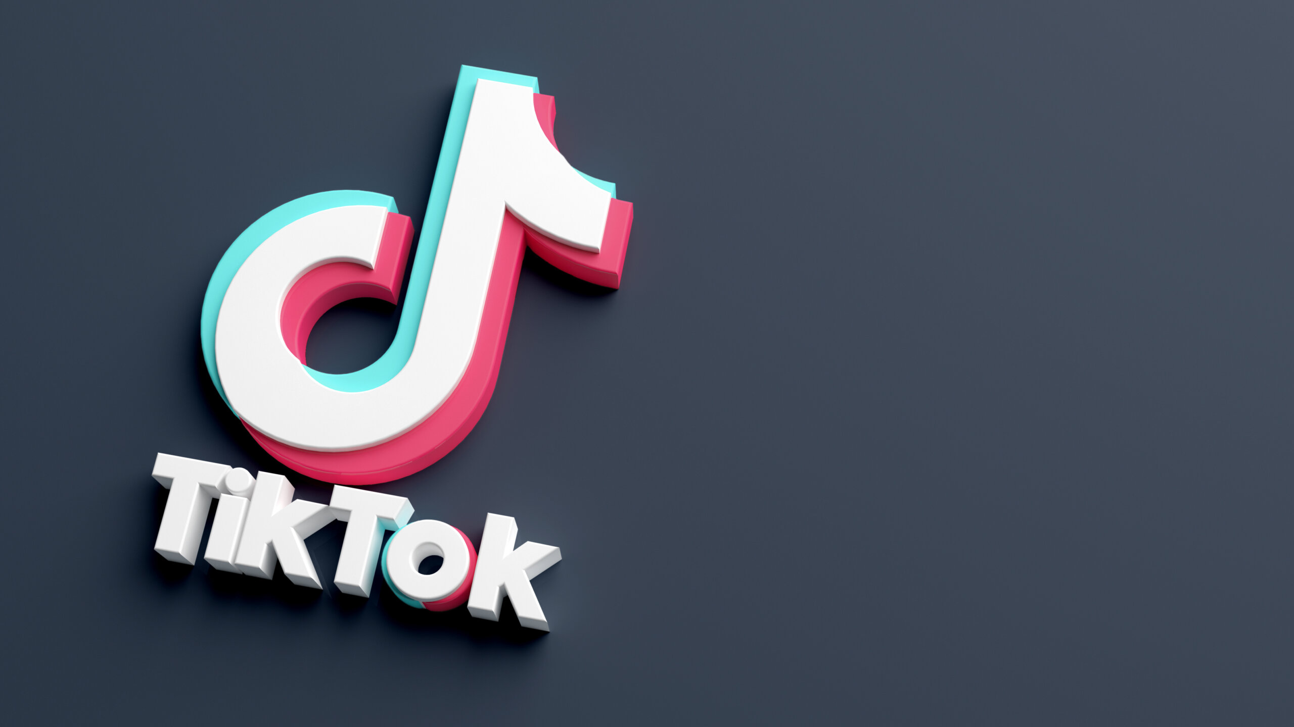 TikTok logo isolated on a dark background and copy space in 3D rendering. Close-up of Tik Tok application logo. Tiktok is a Social media network for videos and music
