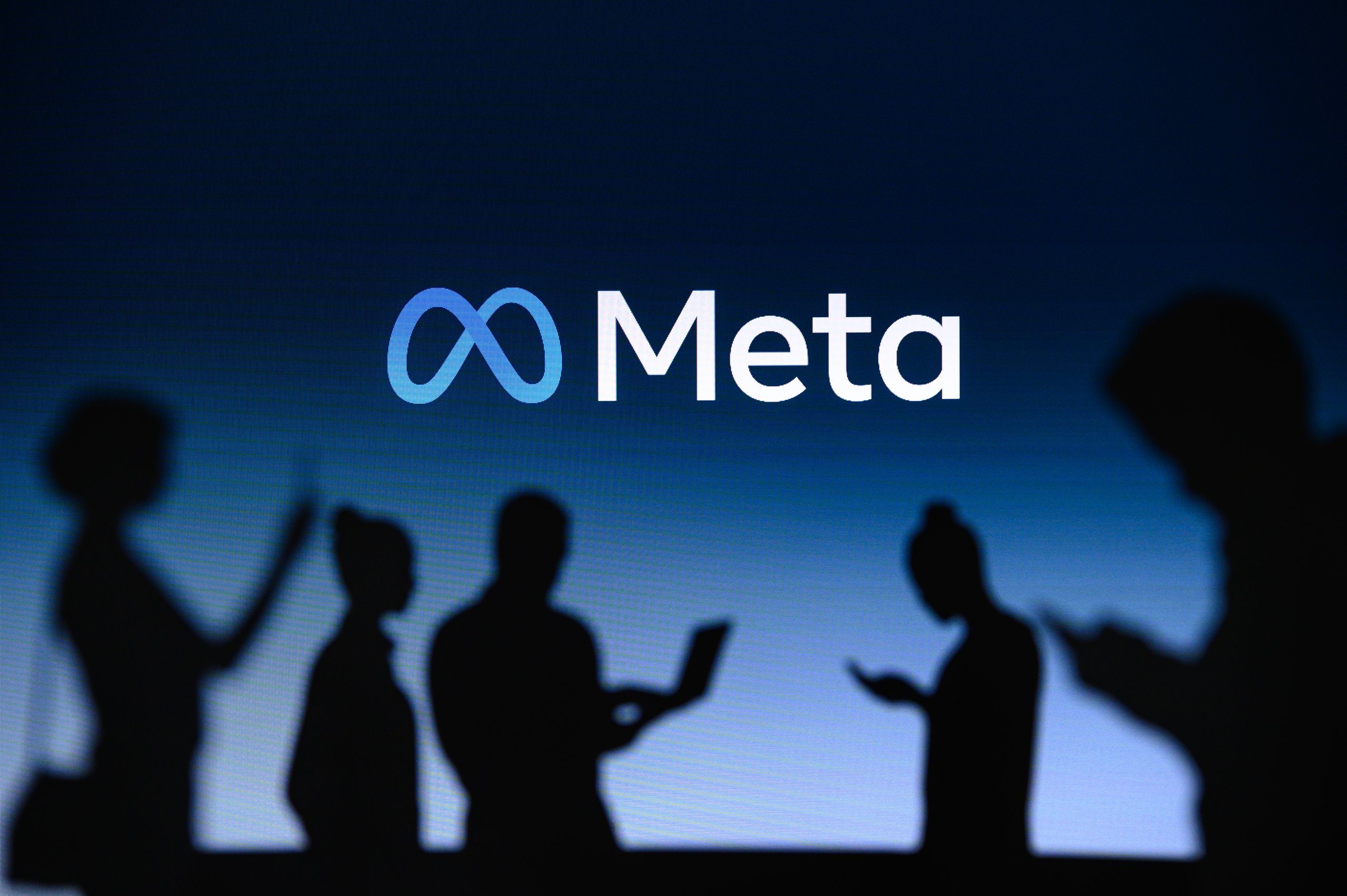 New York, Usa, 1. March 2022: Meta Or Metaverse Logo On Big Screen, Facebook Company, Meta Platforms. Business And Employment Oriented Online Service Group Of Business People Chat On Phone And Laptop
